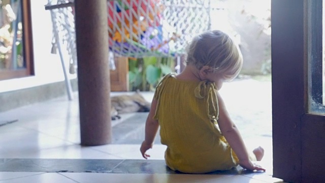 可爱的一岁宝宝坐在台阶上摇摆他或她的腿视频下载