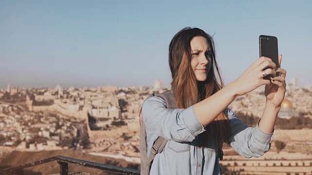漂亮女孩在耶路撒冷老城自拍。可爱的当地女孩微笑快乐，拍照。古以色列全景4K视频素材