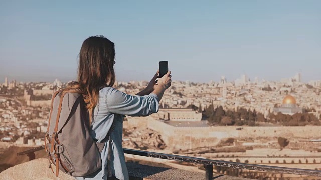 女游客在拍摄耶路撒冷老城的照片。背着背包的女孩走到甲板边缘。捕捉的时刻。以色列4 k视频素材