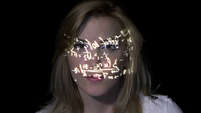 一个聪明的金发女人的肖像思考如何解决积分，而数学公式投射在她的脸上视频素材