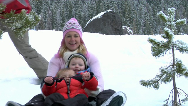 妈妈和孩子们在玩雪橇视频素材