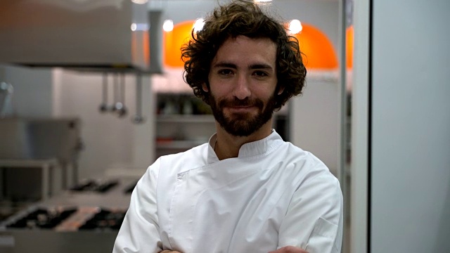 年轻自信的男厨师站在镜头前交叉双臂微笑着视频下载