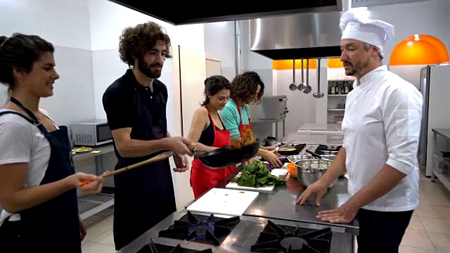 快乐的情侣在烹饪课上，厨师长教他们检查他们在做什么视频素材
