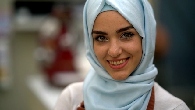 一个美丽的穆斯林餐馆老板在镜头前微笑的特写视频素材