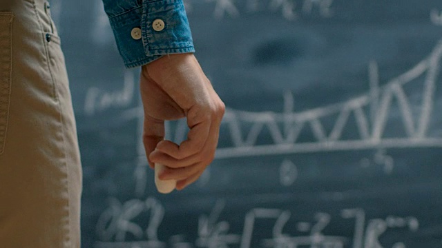 年轻才子在黑板上写下了复杂的数学公式。视频素材