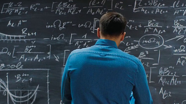 黑板上写着复杂的数学公式/方程，开始思考解决方案。视频素材