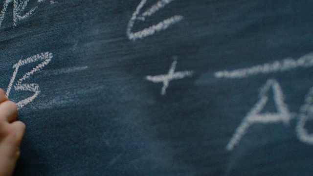 手持粉笔，在黑板上写下复杂复杂的数学公式。突显出方程。视频素材
