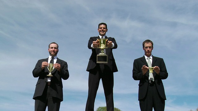 三个拿着奖杯的商人视频素材