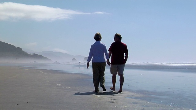 一对老夫妇在海滩上散步视频素材