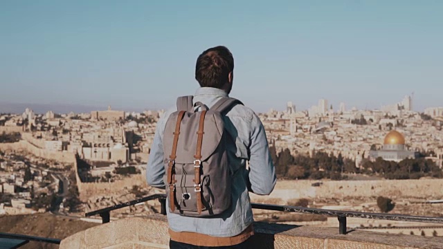 一名男子在以色列耶路撒冷用智能手机拍照。欧洲游客男欣赏古老的风景。旅行。慢动作视频素材