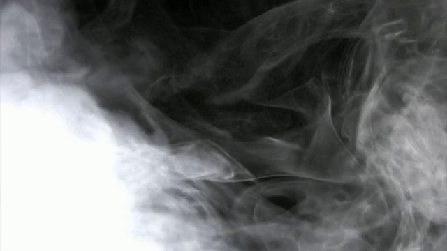 白色的烟雾漂浮在黑色的背景上视频素材