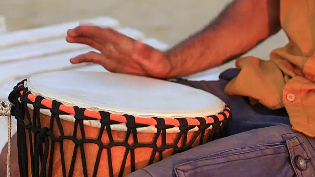 一个人在打邦戈鼓近距离。近距离用手敲邦戈鼓。鼓手，动作，节奏。果阿邦，Arambol海滩。印度视频素材