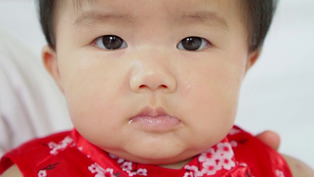 可爱的亚洲小女孩正在四处张望。婴儿脸的特写慢动作镜头。视频素材