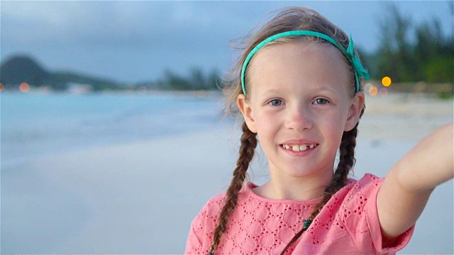 可爱的小女孩在热带白色海滩自拍。慢动作视频下载
