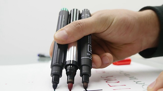 特写男子的手在纸上用记号笔书写视频下载