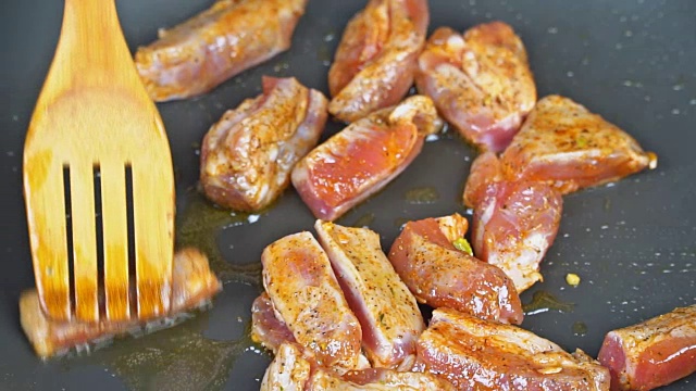 肉切成片在平底锅里炸片片多汁的鲜肉在煎锅里。视频下载