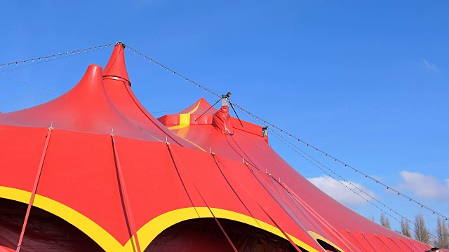 蓝色的天空映衬着红色的马戏团帐篷视频下载