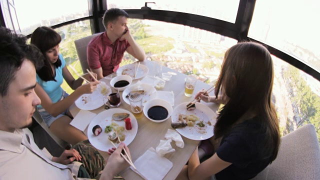 两对年轻夫妇正在用筷子吃亚洲食物视频素材