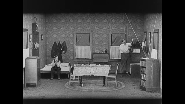 1920年，男人(巴斯特·基顿饰)牙痛坐在床上视频素材