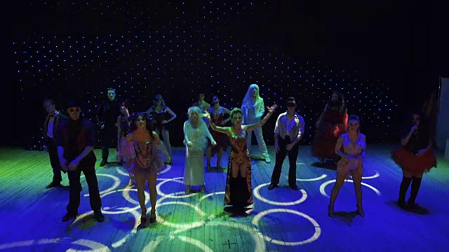 演员们穿着鲜艳的服装在五彩缤纷的舞台上载歌载舞视频素材