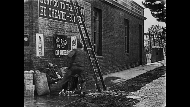 1919年，屋顶上的人(巴斯特·基顿)向下面的人泼水桶视频素材
