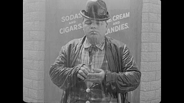 1918年，一名醉汉(胖子阿布克尔)试图在雨中点燃香烟视频素材