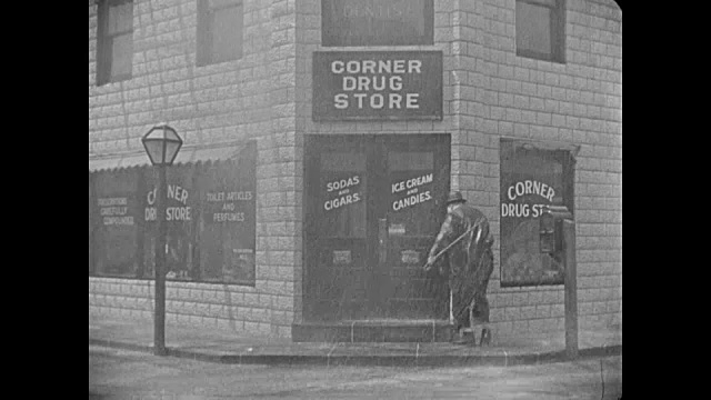 1918年，暴雨中一个醉汉(胖子阿布克尔)帮助另一个醉汉视频素材