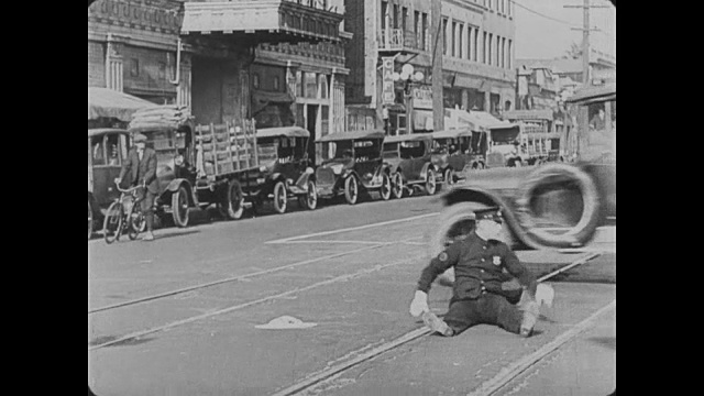 1922年，男人(巴斯特·基顿)在城市街道上被警察追赶视频素材