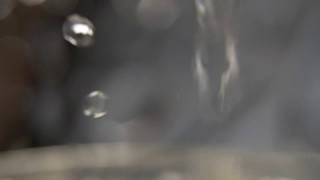 热水倒入玻璃杯中，水飞溅，蒸汽，微距拍摄视频素材