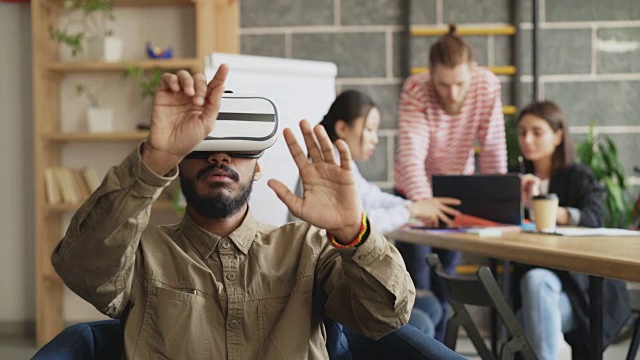 非裔美国人在游戏开发办公室测试VR模拟器。创业创意团队讨论未来虚拟现实技术项目视频素材