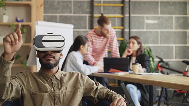 非裔美国人在游戏开发办公室测试VR模拟器。创业创意团队讨论未来虚拟现实技术项目视频素材