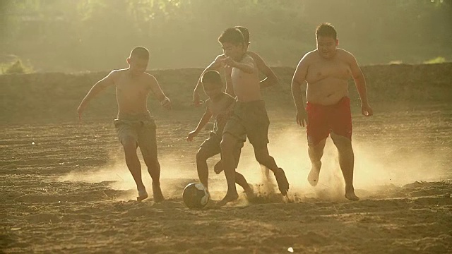 乡村的孩子们在阳光明媚的日子里踢足球。视频素材