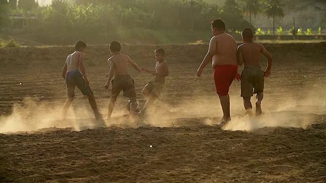 乡村的孩子们在阳光明媚的日子里踢足球。视频素材