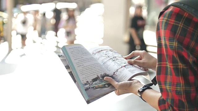 游客行走和使用地图在指南手册找到地铁地图与数字平板电脑视频素材