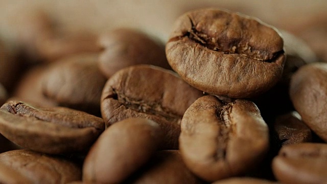 旋转烘焙的咖啡豆在桌上旋转视频下载