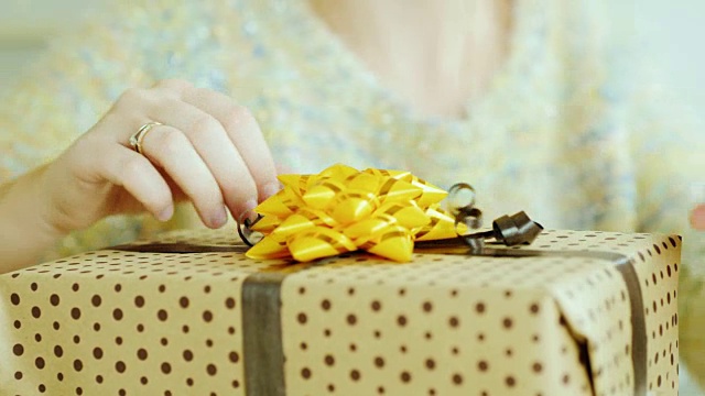 女人们用手整理着礼盒上的丝带和蝴蝶结。特写镜头视频下载