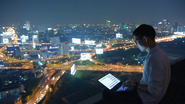 商业使用笔记本电脑和数字平板电脑在摩天大楼的背景视频素材