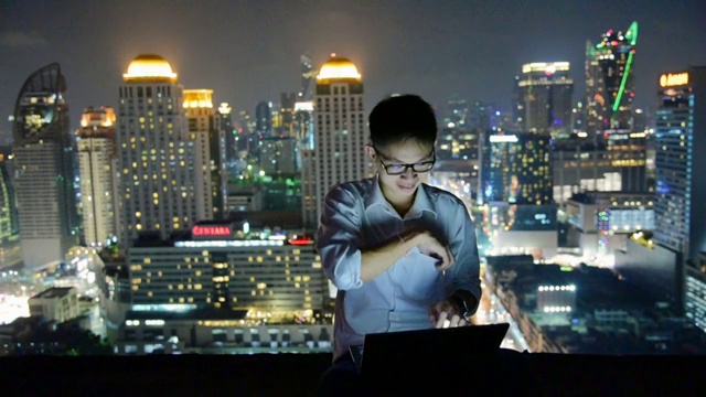 商业使用笔记本电脑和数字平板电脑在摩天大楼的背景视频素材