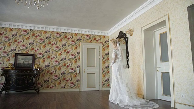 后视图美丽的新娘站在婚纱与面纱在房间视频下载