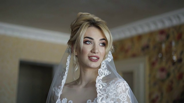 美丽的新娘微笑和轻松的姿势在室内4K相机视频下载