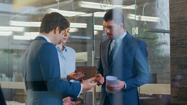 一组男女外交官和商务人士使用平板电脑交谈。高级企业大厦。视频素材