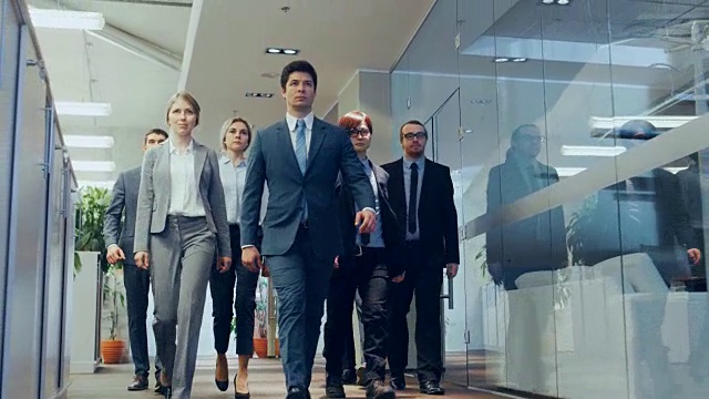多元化的代表/律师团队自信地走过公司大楼走廊。多元文化的人群坚决的商务人士在时尚的大理石和玻璃办公室。视频素材