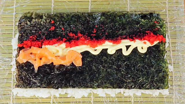 馅料寿司红鱼。厨师的厨师在陆地上裹着红色的鱼。视频素材