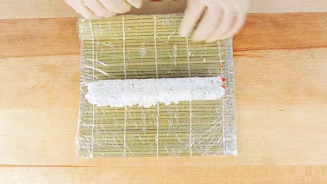 师傅用竹席和海苔制作寿司卷视频素材