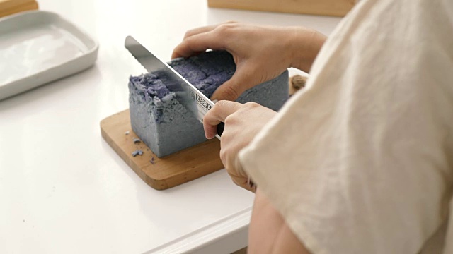亚洲妇女的小生意是制作有机肥皂的过程中切割，同时使用硬木制面包肥皂刀具手工精密切割肥皂修剪她的手工肥皂在她的房间视频下载