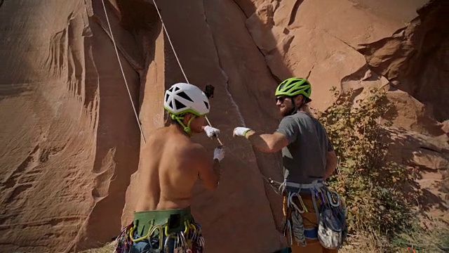 攀岩者和保护员在准备上坡时互击拳头。视频素材