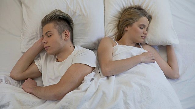 年轻夫妇安静地睡在舒适的整形床垫上，放松地做梦视频下载