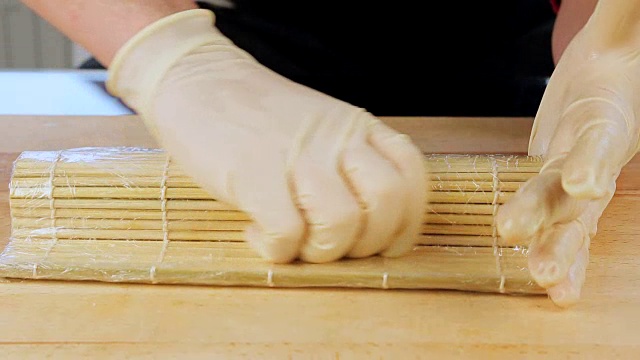 师傅用竹席和海苔制作寿司卷视频素材
