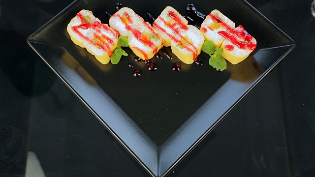 寿司放在黑色盘子里，用姜饼上的玫瑰装饰视频素材