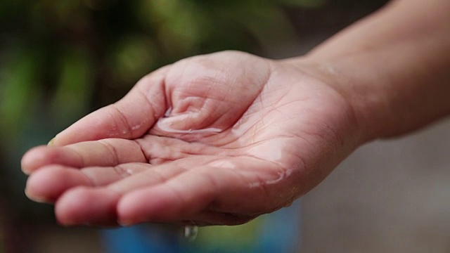 在雨水下女人的手的特写。视频素材